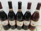 six bouteilles de vin sont alignées sur un sol carrelé