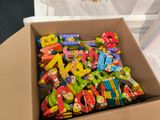a cardboard box filled with lots of colorful wooden toys