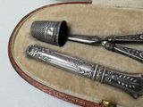 three silverware items in a case on a table