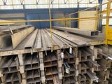 a large pile of steel beams in a warehouse
