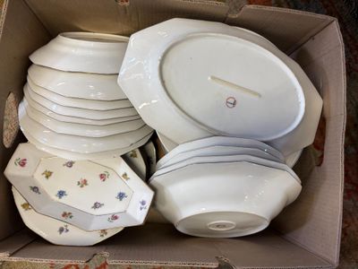 many plates and bowls in a box on the floor
