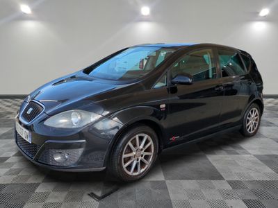 a black car parked in a garage with a checkered floor