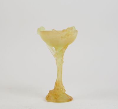 un gros plan d'un verre jaune posé sur une surface blanche
