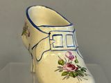 a white shoe with blue trim and flowers on it
