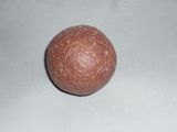 une petite boule orange posée sur une surface blanche