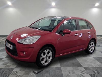 une voiture rouge est garée sur le sol en damier d'un garage