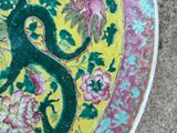 a yellow plate with a green tree and flowers on it