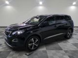 Un SUV noir est garé dans une grande pièce au sol carrelé.