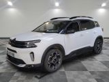 un 4x4 blanc garé sur un sol en damier dans un garage