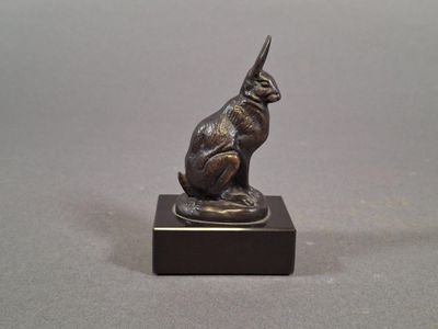an image of a bronze statue of a cat sitting on top of a wooden base