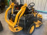 une tondeuse à gazon jaune sur laquelle on peut monter, garée dans un garage