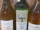 three bottles of wine are sitting on a table in front of a cardboard box