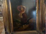 un vieux tableau représentant une femme en robe rouge est posé sur un tapis