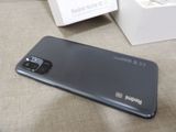 a black phone sitting on a table next to a box
