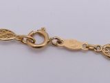a close up of a gold bracelet on a white surface