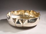 silver plated bowl sitting on top of a white surface