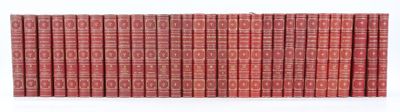 Les livres rouges sont alignés contre un mur blanc.