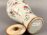 a white vase with a floral design on it