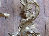 a pair of ornate gold wall sconces on a wooden floor