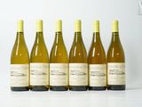 six bouteilles de vin sont alignées sur une table