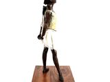 statue of a boy with a baseball bat on a wooden base