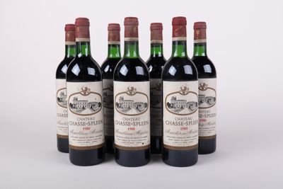 quatre bouteilles de vin sont alignées sur une surface blanche