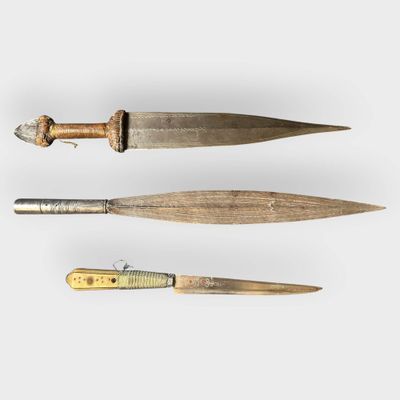 two old knives are sitting next to each other on a white surface