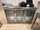 a metal counter with two glass doors and a laptop on top