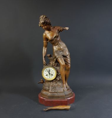 a statue of a woman with a clock on a table