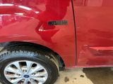 a red car that has been dented and has a sticker on it