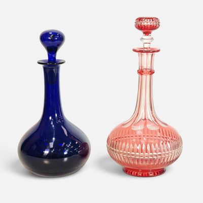 une paire de bouteilles en verre bleues et roses munies d'un bouchon rouge