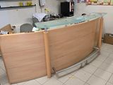 un comptoir d'accueil avec un plateau en verre, situé dans une petite pièce