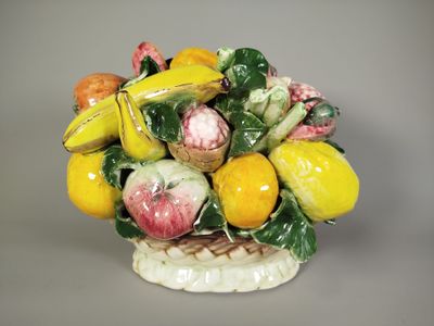 un vase en céramique orné d'un bouquet de fruits