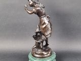 bronze statue of a boy with a dog on a marble base