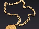 un collier en or avec un médaillon suspendu à une chaîne