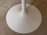 a white table with a glass top on a carpeted floor