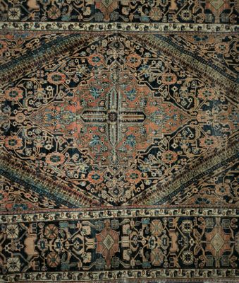 un tapis persan ancien, au motif complexe sur fond noir