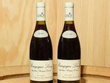 deux bouteilles de vin posées l'une à côté de l'autre sur un tonneau