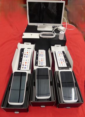 quatre téléphones portables et un ordinateur portable posés sur une table rouge