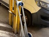 une camionnette blanche garée à côté d'un poteau jaune
