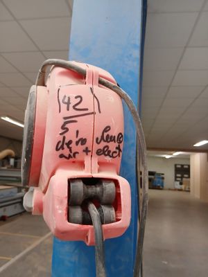 une bouche d'incendie rose fixée à un poteau dans un entrepôt