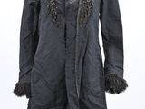an image of a black coat on a mannequin stand with a white background