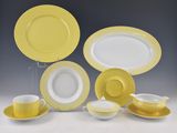 a group of yellow and white dishes and cups and saucers