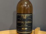 Des bouteilles de vin sont posées sur une table en bois dans une pièce.