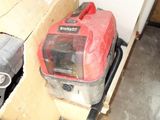 a red and black vacuum sitting in a room