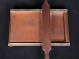 a small knife on a wooden tray on a black surface