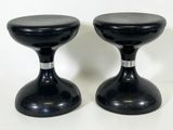 une paire de tabourets noirs posés sur une surface blanche