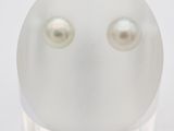 a close up of a white object with two pearls on it