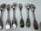 six spoons and six forks sitting on a table