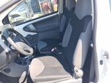the interior of a small white car with the door open